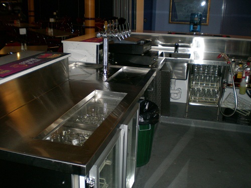 Stainless bar wells and drainboard behind a counter